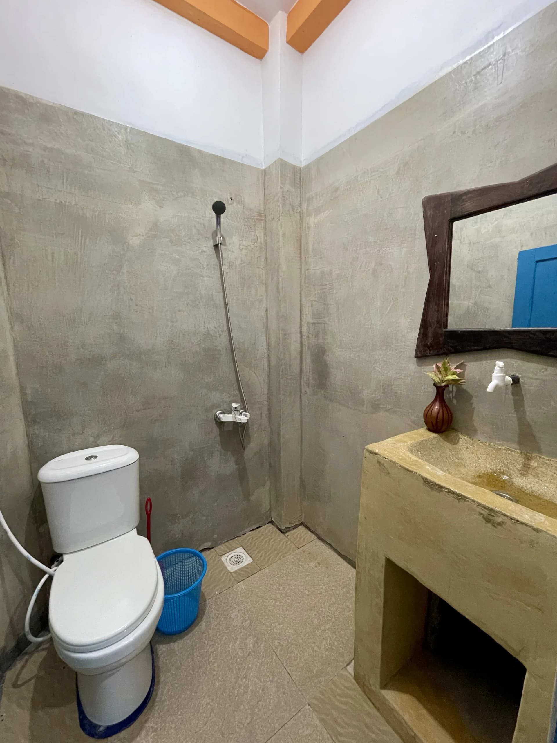Clean en-suite bathroom with artisanal cement vanity and mirror at Anu Villa