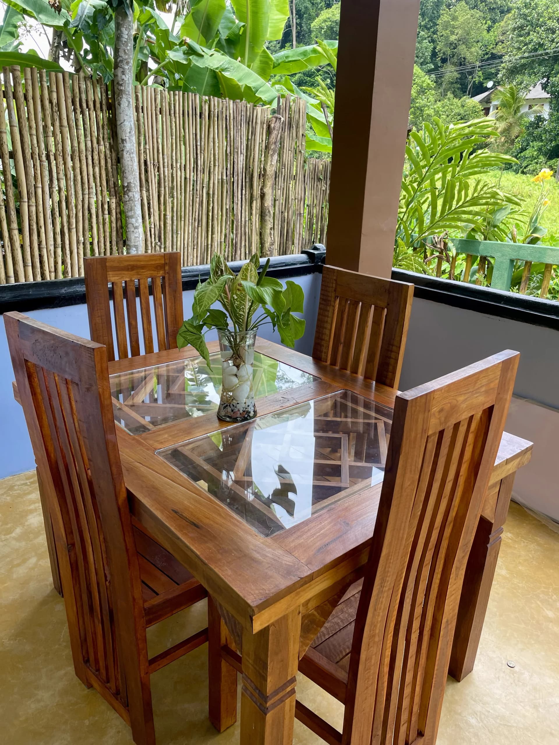 Tropical veranda dining table with lush garden backdrop at M.S.A Anu Villa