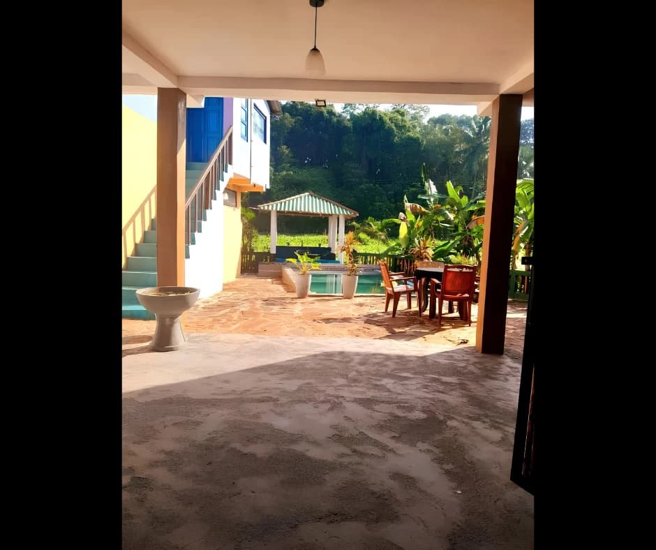 Covered ground floor veranda lounge with pool and tropical palm views